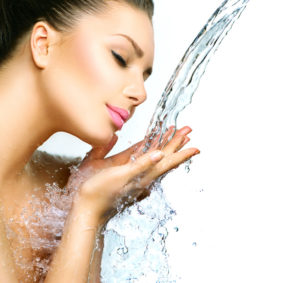 Beautiful woman with splashes of water in her hands